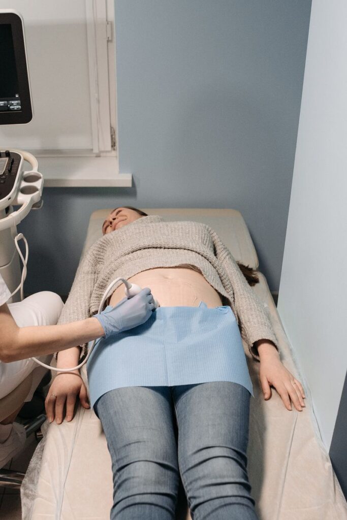 Healthcare professional performing an ultrasound scan on a patient in a medical clinic.